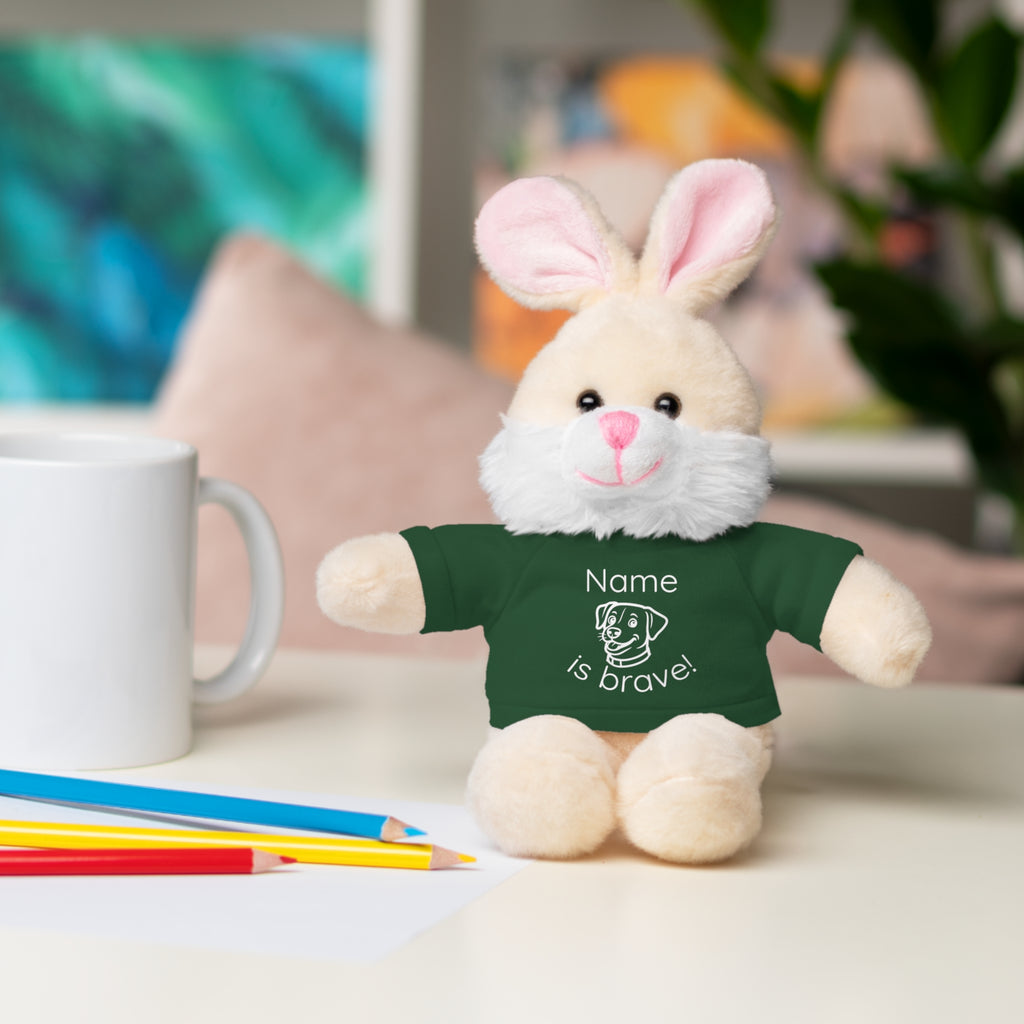Soft off white plush bunny wearing a Name is Brave personalized forest green  tee shirt - sitting on desk with colored pencils