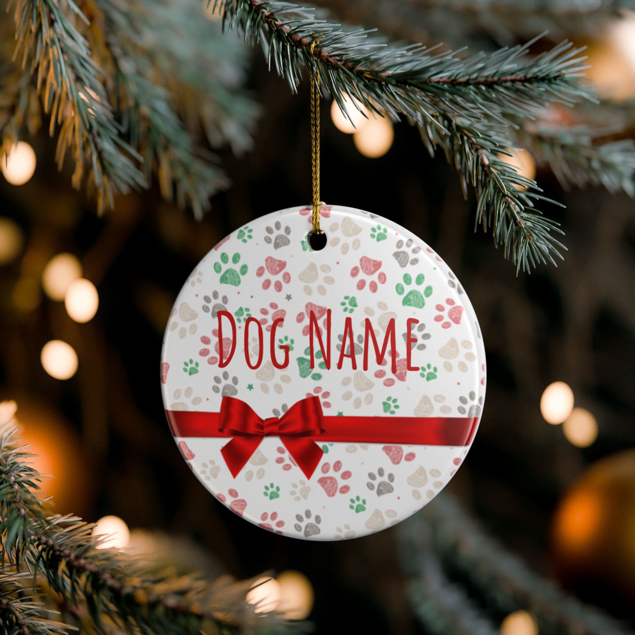 Round ceramic Christmas ornament with paw prints and custom dog name on tree