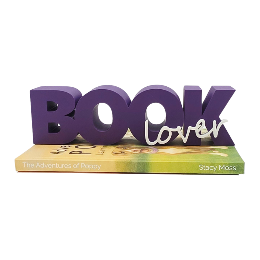 Purple 'Book Lover' decorative piece on a book with a white background