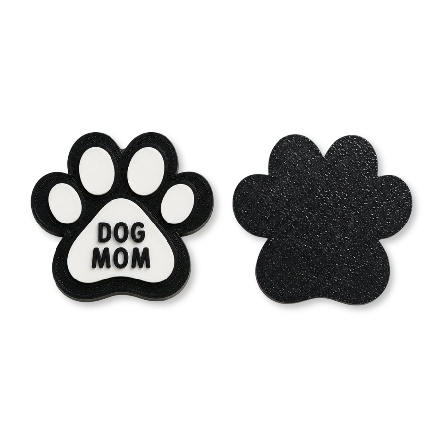 Paw-shaped 'Dog Mom' magnet and solid black paw-shaped object on a white background