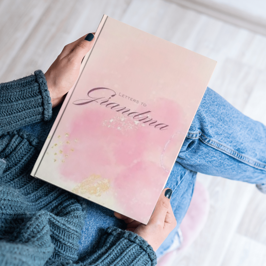 Letters to Grandma journal held by person in blue sweater showing cover
